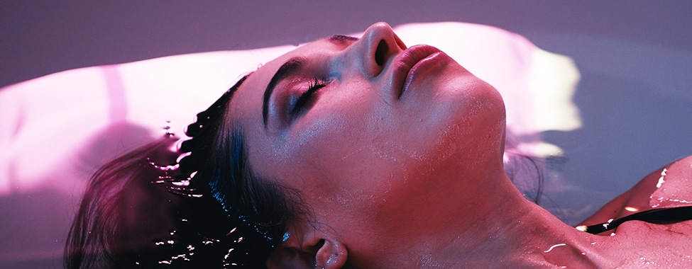 Young woman floating in Spa bath or swimming pool, she is very relaxed. Wellness concept