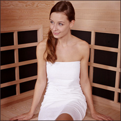 Woman in a towel sitting in an infrared sauna