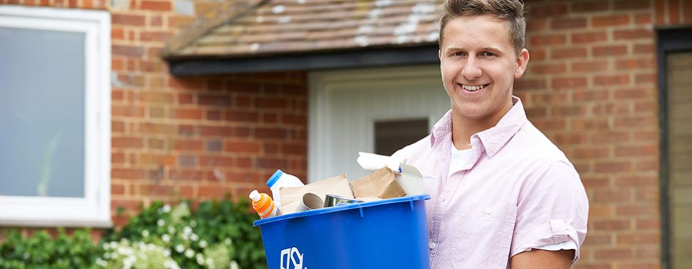 Portrait Of Man Carrying Recycling Bin