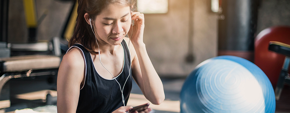 Woman-Listening-to-Best-Fitness-Podcasts-in-Gym