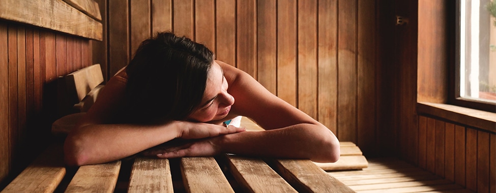 Woman using a sauna to stay warm in the winter