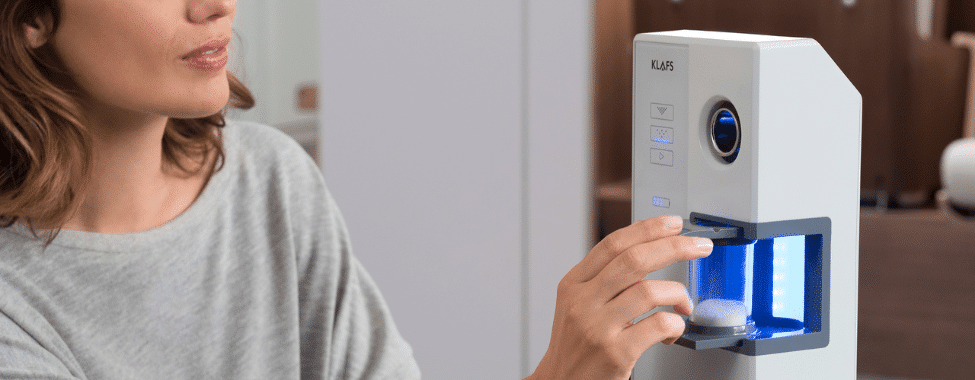 A woman placing a vial of salt into a device
