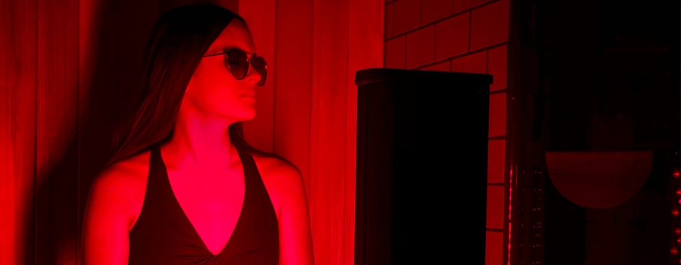 Woman Using Trendy Infrared Sauna with Red Light