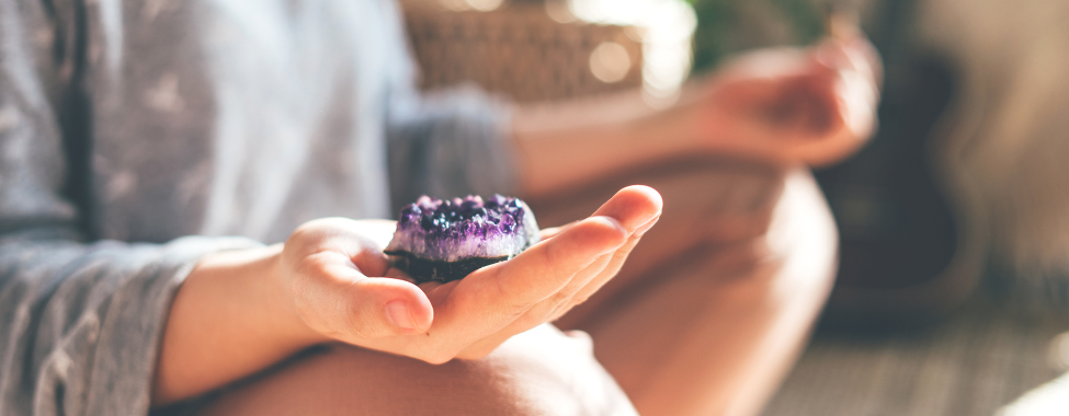 Person Using Amethyst Crystals in Wellness Routine