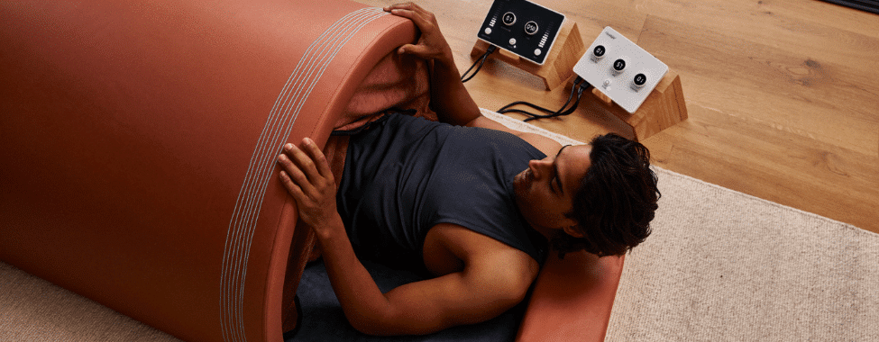 Man lying on his back inside a Curve infrared sauna dome