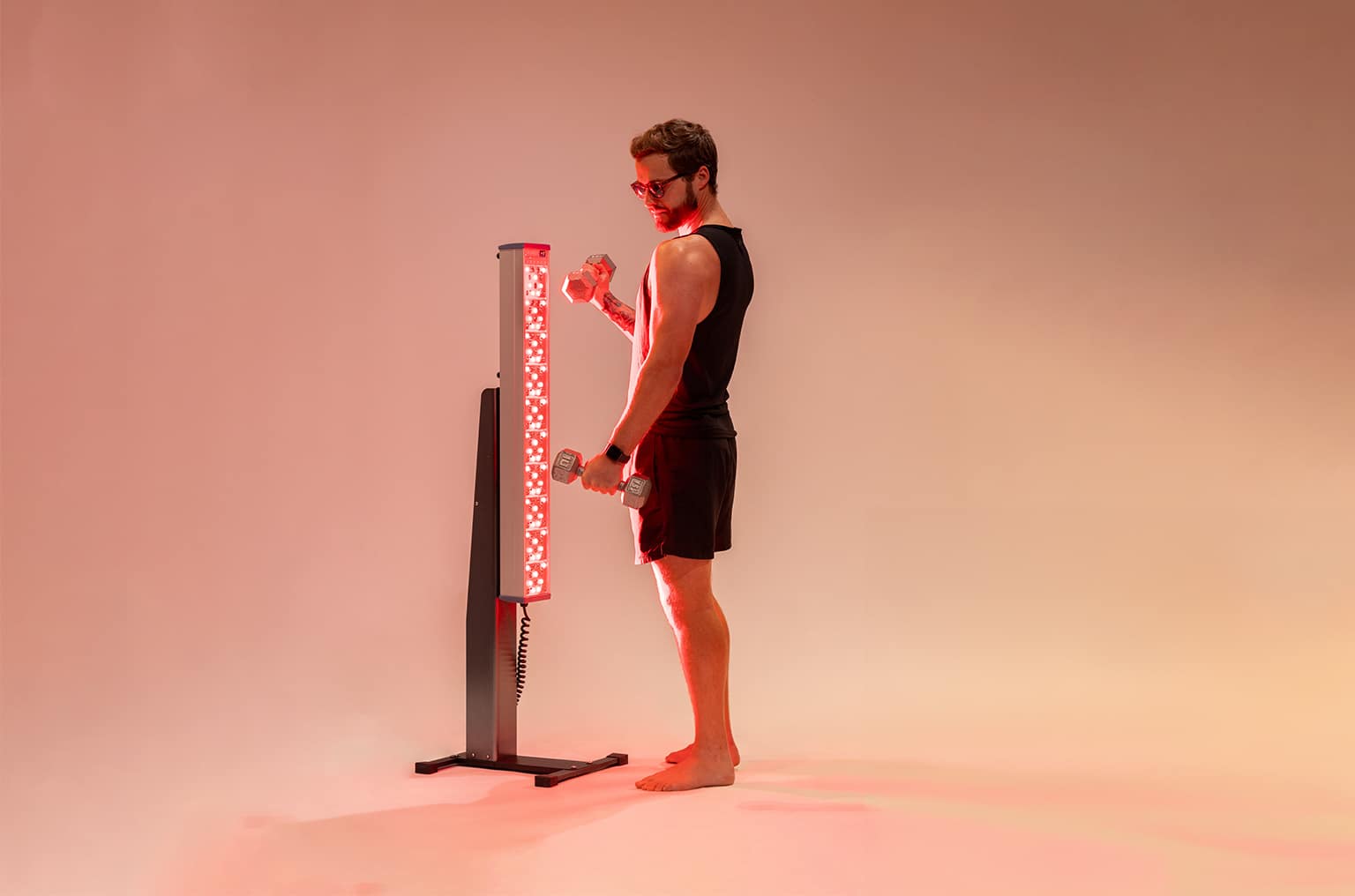 Man Lifting Weights Next to Red Light Tower