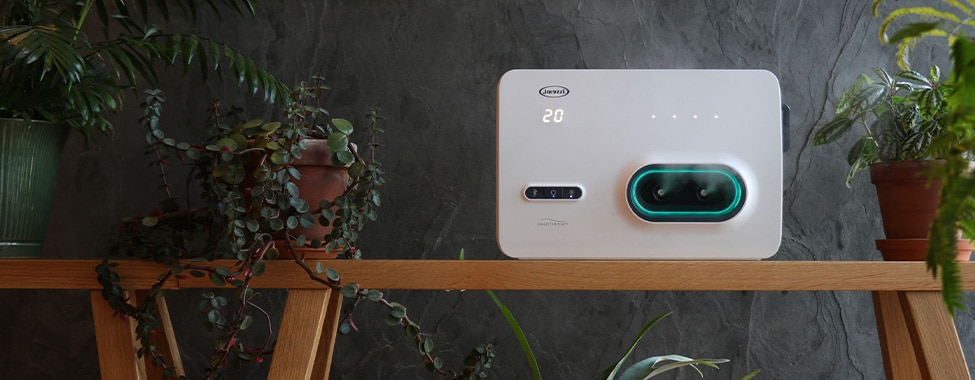 Clearlight HALO ONE halotherapy device on a wooden table, emitting a green glow for dry salt therapy and respiratory wellness