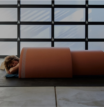 A woman laying facedown under the Curve Sauna Dome