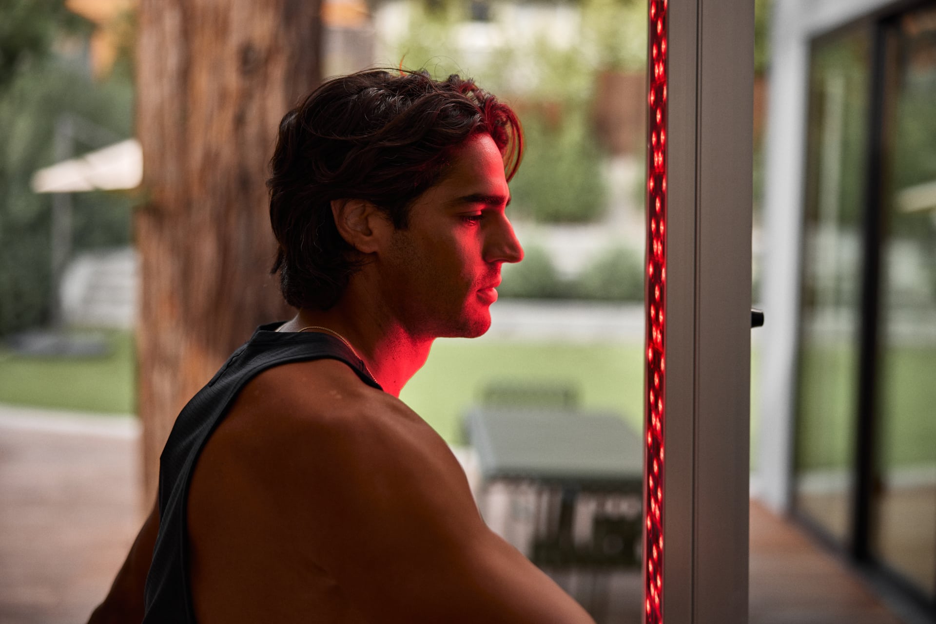 young adult male using Red Light Therapy tower